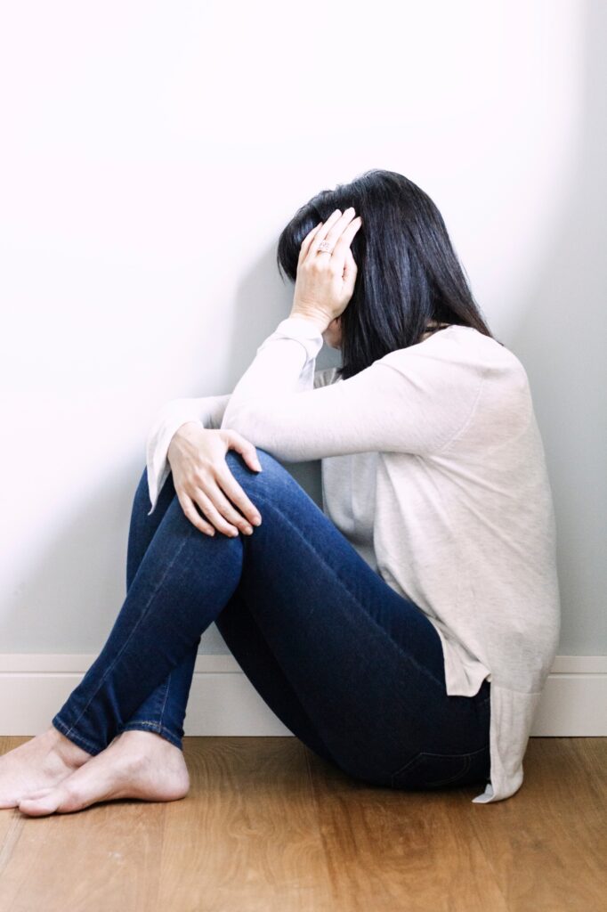 Woman looking depressed, hand on head, social distancing, illness, mental illnesss, psychology